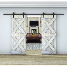 an open barn door with a tv on the wall and a coffee table in front of it