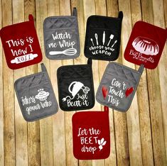 six oven mitts with different sayings on them sitting on top of a wooden table