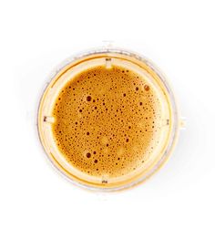 an overhead view of a cup of coffee on a white background with the top down