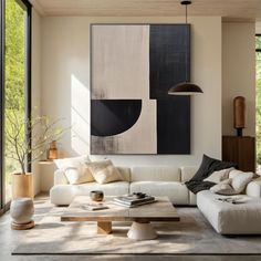 a modern living room with white furniture and large painting hanging on the wall above it