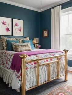 a bedroom with blue walls, gold bed frame and floral bedspread in the middle