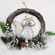 a christmas ornament with a raccoon and pine cones