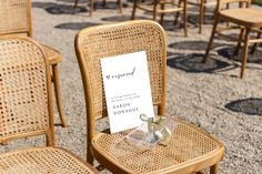 there are many chairs with signs on them in the middle of a gravel area that has been set up