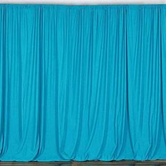 an empty room with blue drapes on the wall