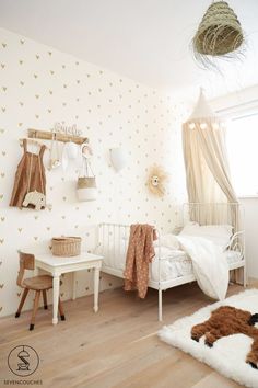 a child's bedroom decorated in white and gold with hearts on the wallpaper