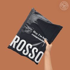 a person holding up a black bag with the word rosso printed on it