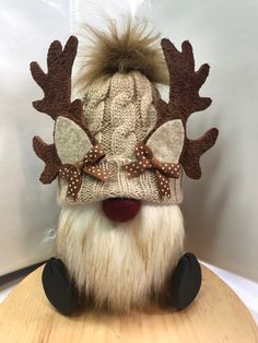 a stuffed animal wearing a knitted hat with deer antlers on it's head