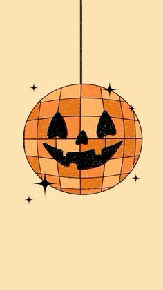 an orange and black pumpkin hanging from a wire with stars on it's sides