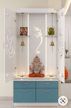 a white room with blue drawers and shelves on the wall next to a buddha statue