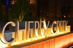 the sign for cherry creek is lit up at night