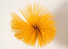 a bunch of yellow straws sitting on top of a white table