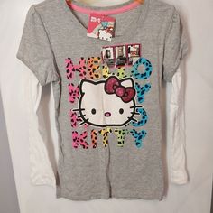 This Hello Kitty Jersey Is A Must-Have For Any Young Girl's Wardrobe. The Gray Cotton Blend Material Is Lightweight And Easy To Care For, Making It Perfect For All Seasons. The Long Sleeve Top Features A Crew Neck And A Regular Fit, With The Iconic Hello Kitty Character And Animal Print Pattern Adding A Touch Of Fun To Any Outfit. Whether Your Child Is Walking To School, Playing Baseball, Or Dancing, This Jersey Is Comfortable And Stylish. The Size L Top Is Suitable For Girls And The Material Is Hello Kitty Top, Walking To School, Walk To School, Hello Kitty Characters, Animal Print Pattern, Top Girls, Play Baseball, Animal Prints Pattern, Girls Wardrobe