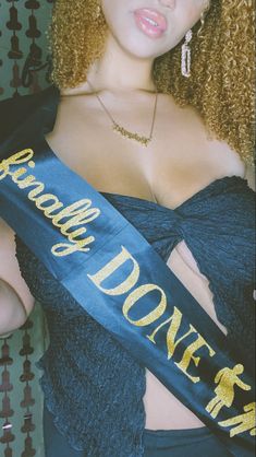 a woman wearing a blue sash with gold lettering on it