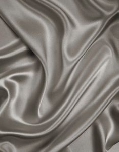 an up close shot of a satin fabric with very smooth lines and folds on it