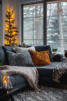 a living room filled with furniture and a christmas tree in the window sill next to it