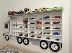 a toy truck is mounted to the wall next to a shelf with cars on it