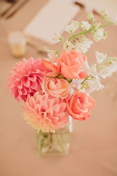 a vase filled with pink and white flowers next to a bible verse on the wall