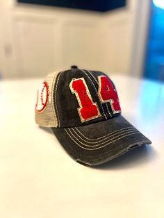 This custom Baseball mom hat is perfect for any game! Put your Childs number on the hat with a Baseball on the side! Hats come in a variety of colors and the number patches come in red, black, or white with a glittered gold background. If you do not see the color hat you are looking for just contact me! Numbers are approximately 3 inches long and made out of Chenille. First two pictures are shown in Black/ Khaki and Hot Pink/Khaki I also have Football and Soccer hats here... https://www.etsy.com Baseball Mom Hat, Baseball Mom Gifts, Mom Hat, Sports Mom Shirts, Mom Hats, Patch Hat, Hat Patches, Purple Design, Custom Football