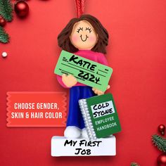 a christmas ornament with a woman holding a sign that says, my first job