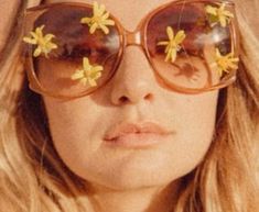 a close up of a person wearing sunglasses with flowers on them