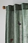 a curtain with birds on it in front of a white wall and window sill