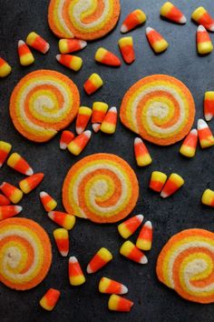 candy candies arranged on a black surface with orange, yellow and white swirls