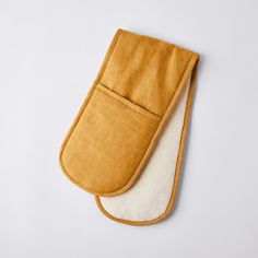 an oven mitt on top of a white surface with a brown and cream lining