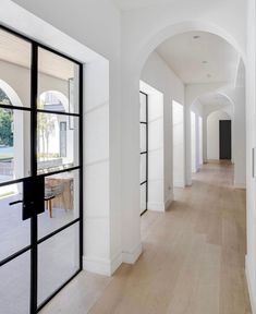 an empty hallway with black glass doors and white walls