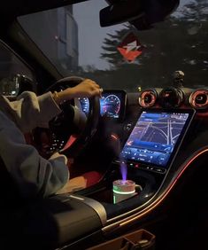 a man driving a car at night with his phone in the front seat and other electronic devices on the dashboard