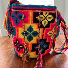 a multicolored woven purse with tassels