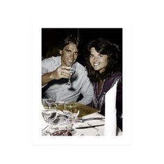 a man and woman sitting at a table with wine glasses