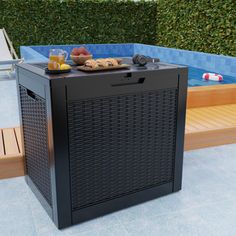 an outdoor hot tub next to a swimming pool with drinks on it and two lounge chairs in the background