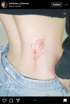 a woman's lower back tattoo with red ink on her left ribcage