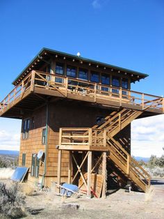 a tall wooden building with stairs leading up to it's second story and balcony