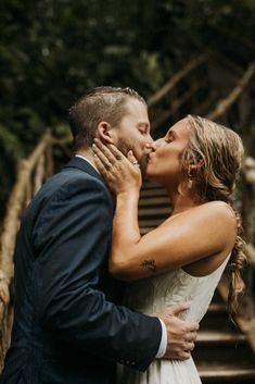 a bride and groom kissing on the stairs at their outdoor wedding ceremony in costa rica, costa rica