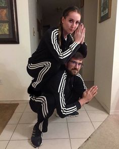 a man and woman posing for a photo in front of the camera with their hands together