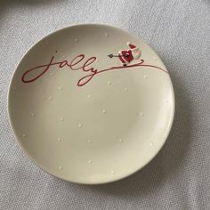 a white plate with red writing on it that says jally and has a bird