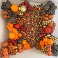 an arrangement of balloons and pumpkins are arranged in the shape of a large star