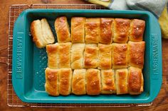 a blue tray filled with bread on top of a wooden table