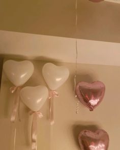 three heart shaped balloons hanging from the ceiling