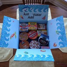 an open cardboard box filled with lots of different items on top of a wooden table