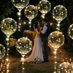 a bride and groom standing in front of bubbles with candles on the ground next to them