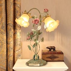 a lamp that is sitting on top of a table next to a box and suitcase