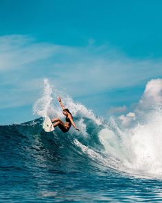 a man riding a wave on top of a white surfboard in the middle of the ocean