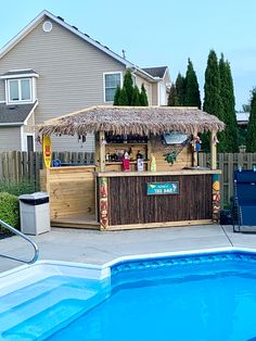 an outdoor bar next to a pool with a straw umbrella over it and chairs around the pool