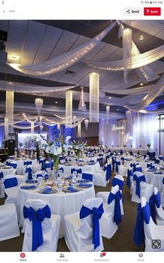 the banquet hall is decorated with blue and white linens, sashes, and centerpieces