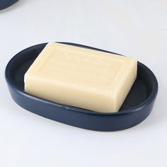 a bar of soap sitting on top of a blue plate next to a white background