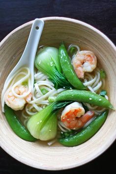 a bowl filled with noodles, shrimp and vegetables