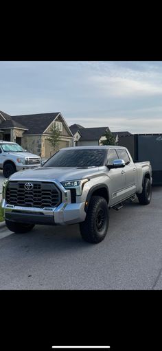 a silver truck is parked in front of some houses