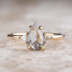 a yellow gold engagement ring with two pear shaped diamonds